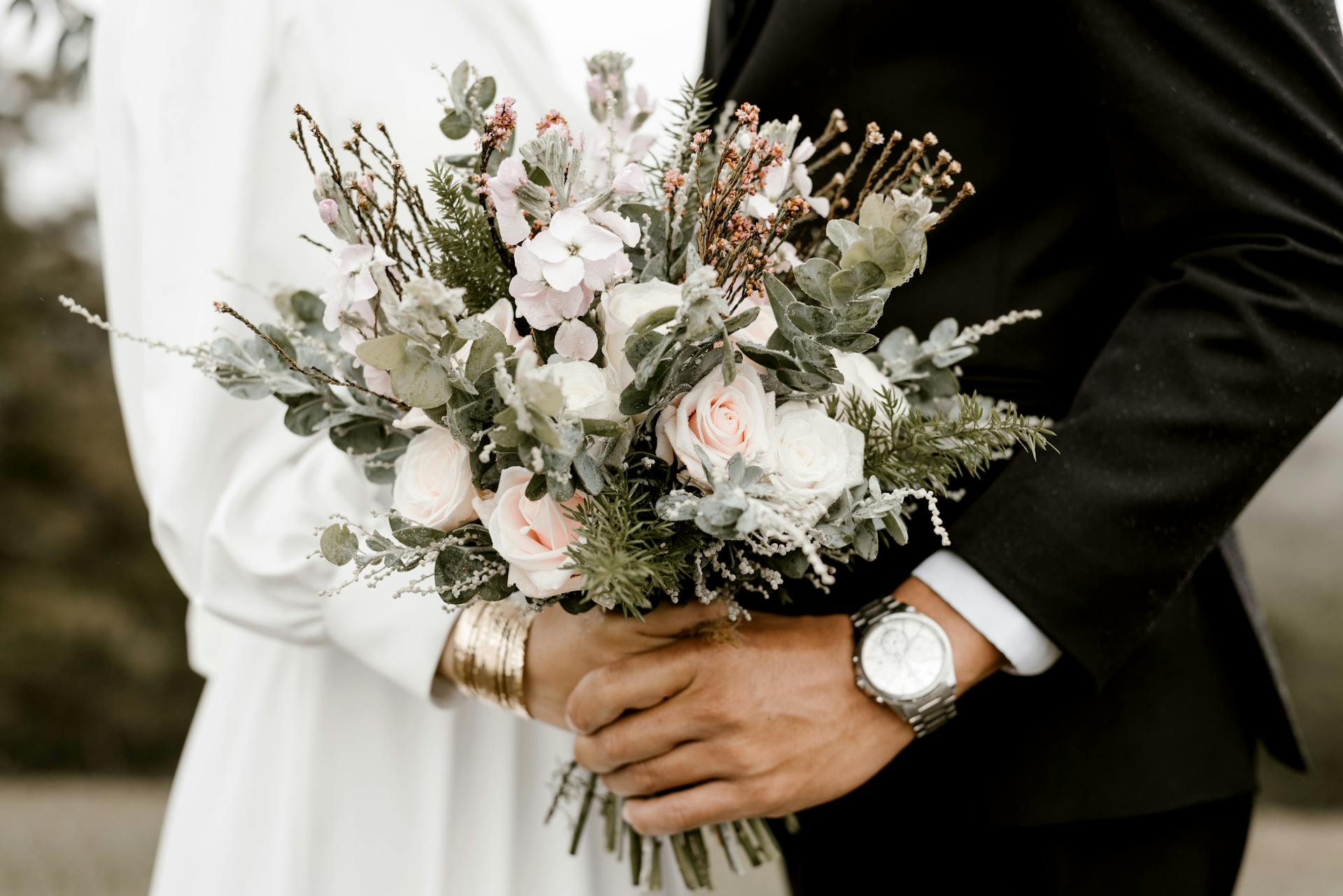 A closeup shot of a bride and groom holding a bouquet | Source: Pexels