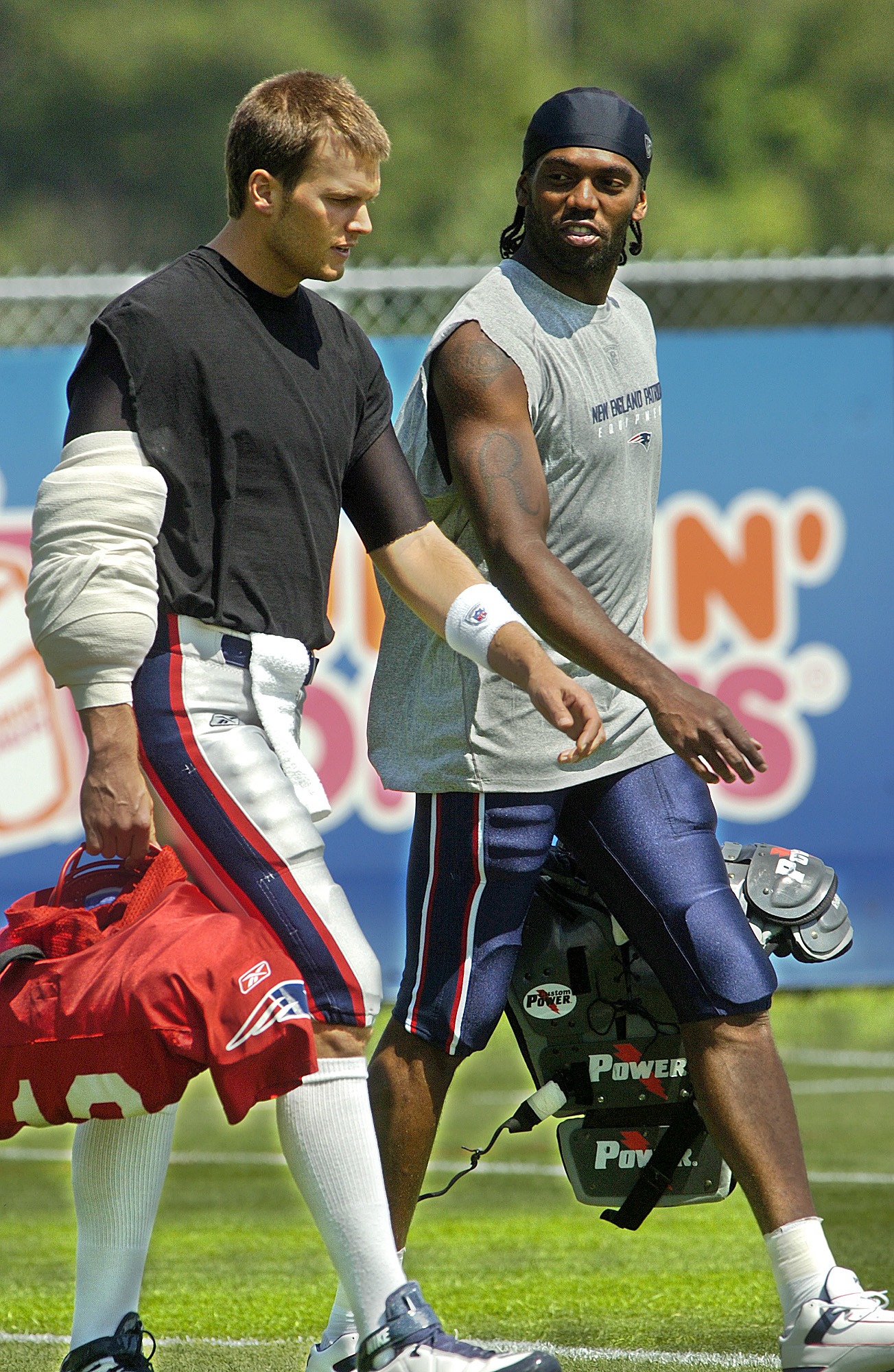 Tom Brady and Randy Moss walk onto the field at the start of practice at Gillette Stadium, on July 8, 2008 | Source: Getty Images