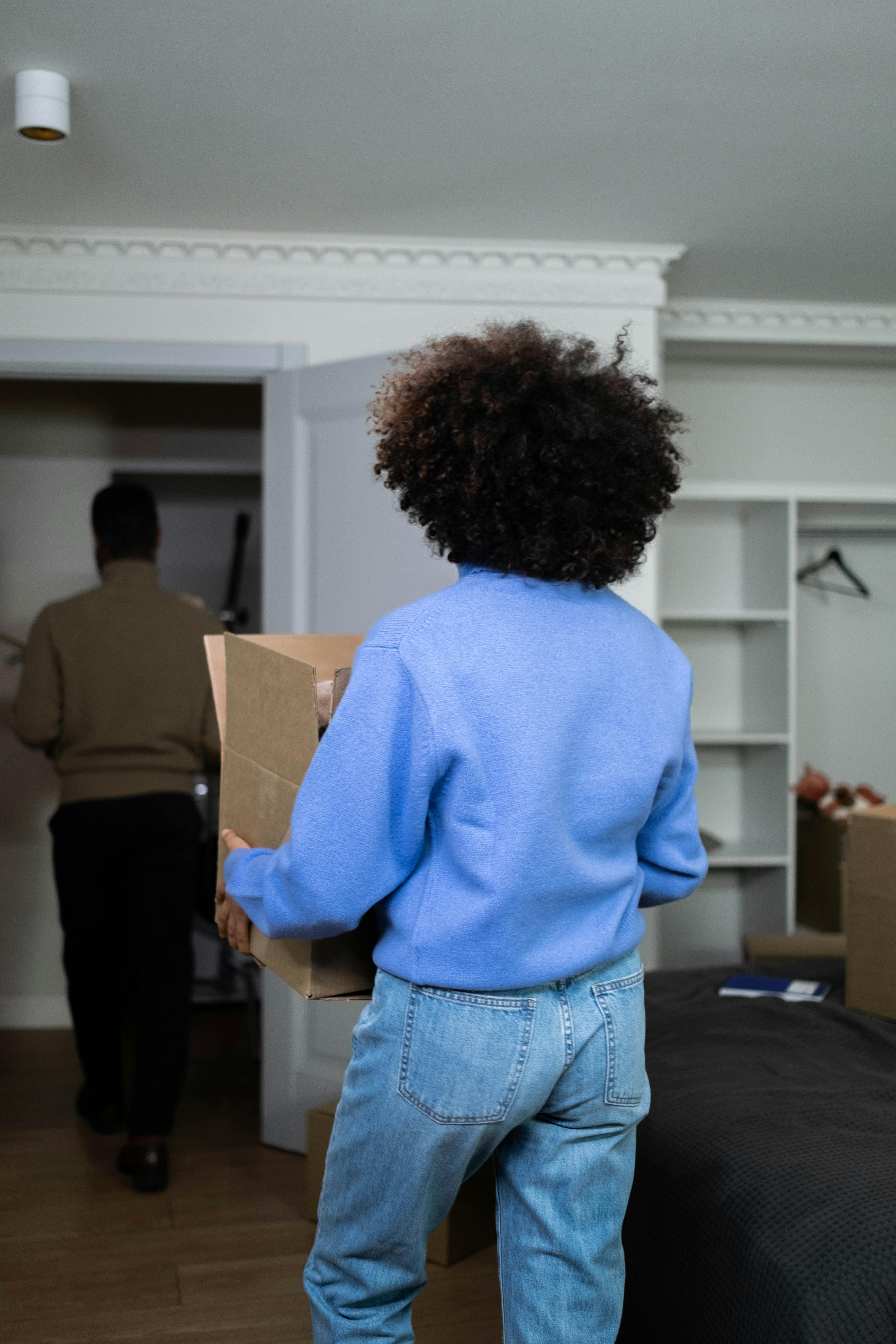 A couple walking out of the house with boxes | Source: Pexels