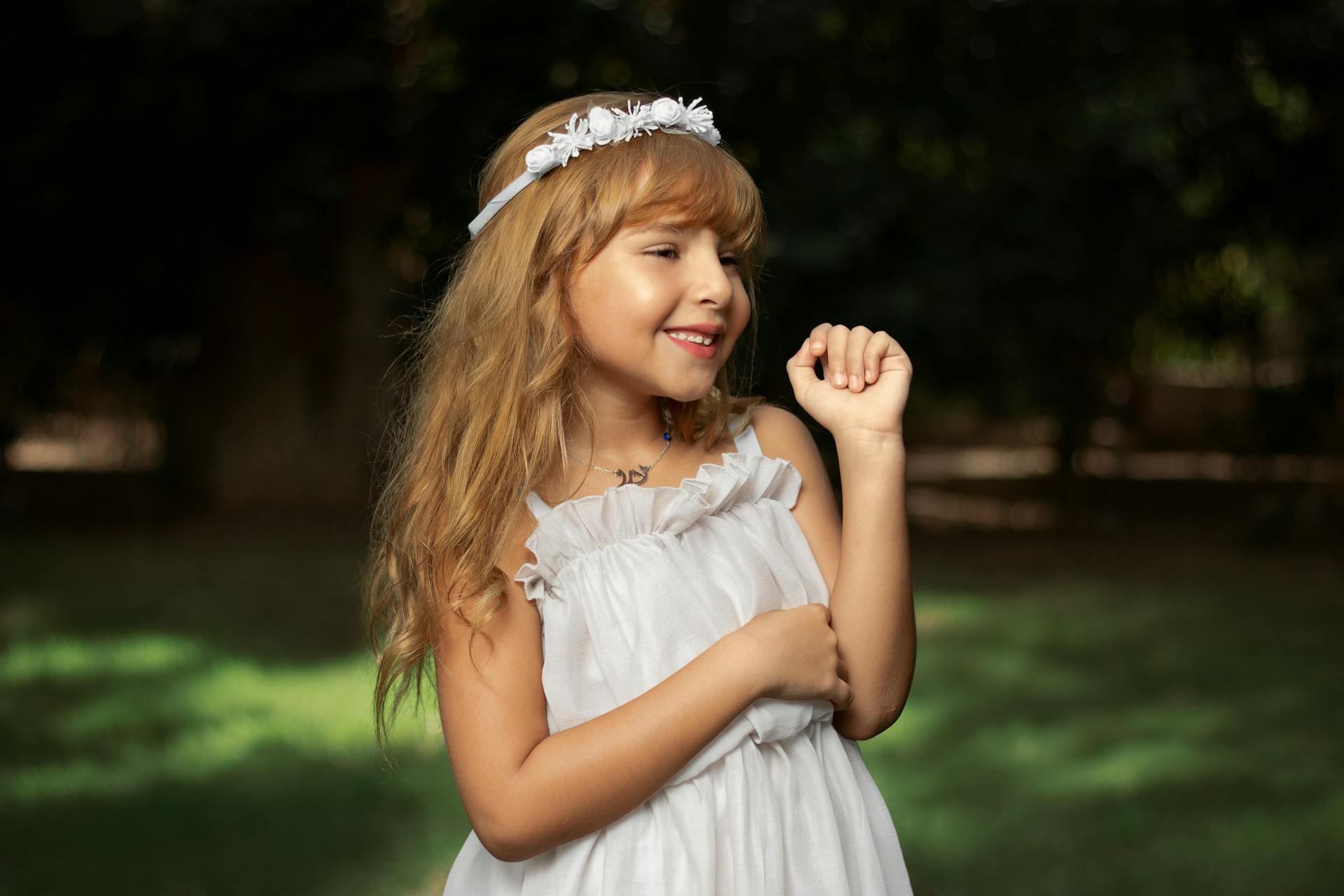 A happy little girl in a white dress | Source: Pexels