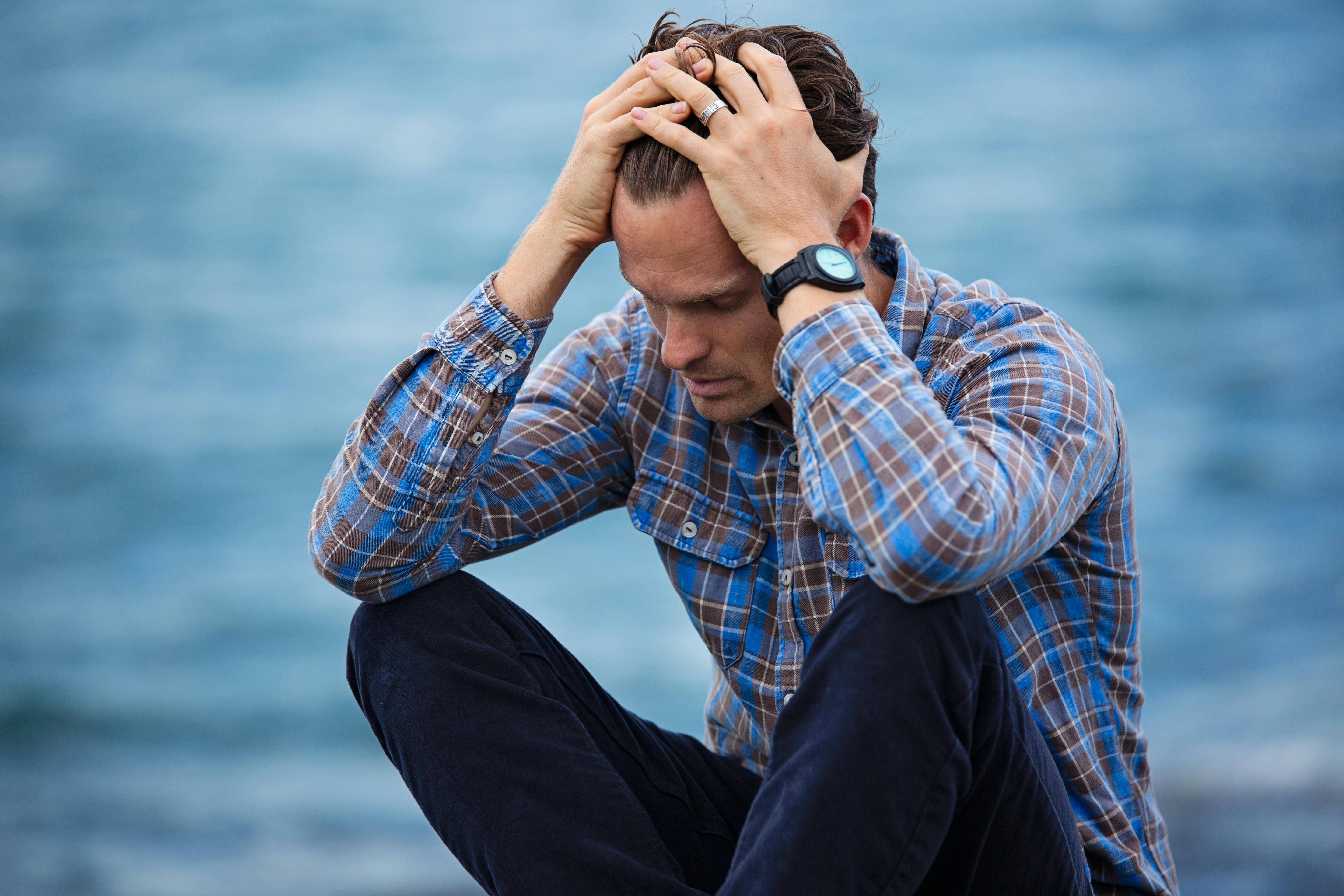 A man in despair sittting by the water | Source: Pexels