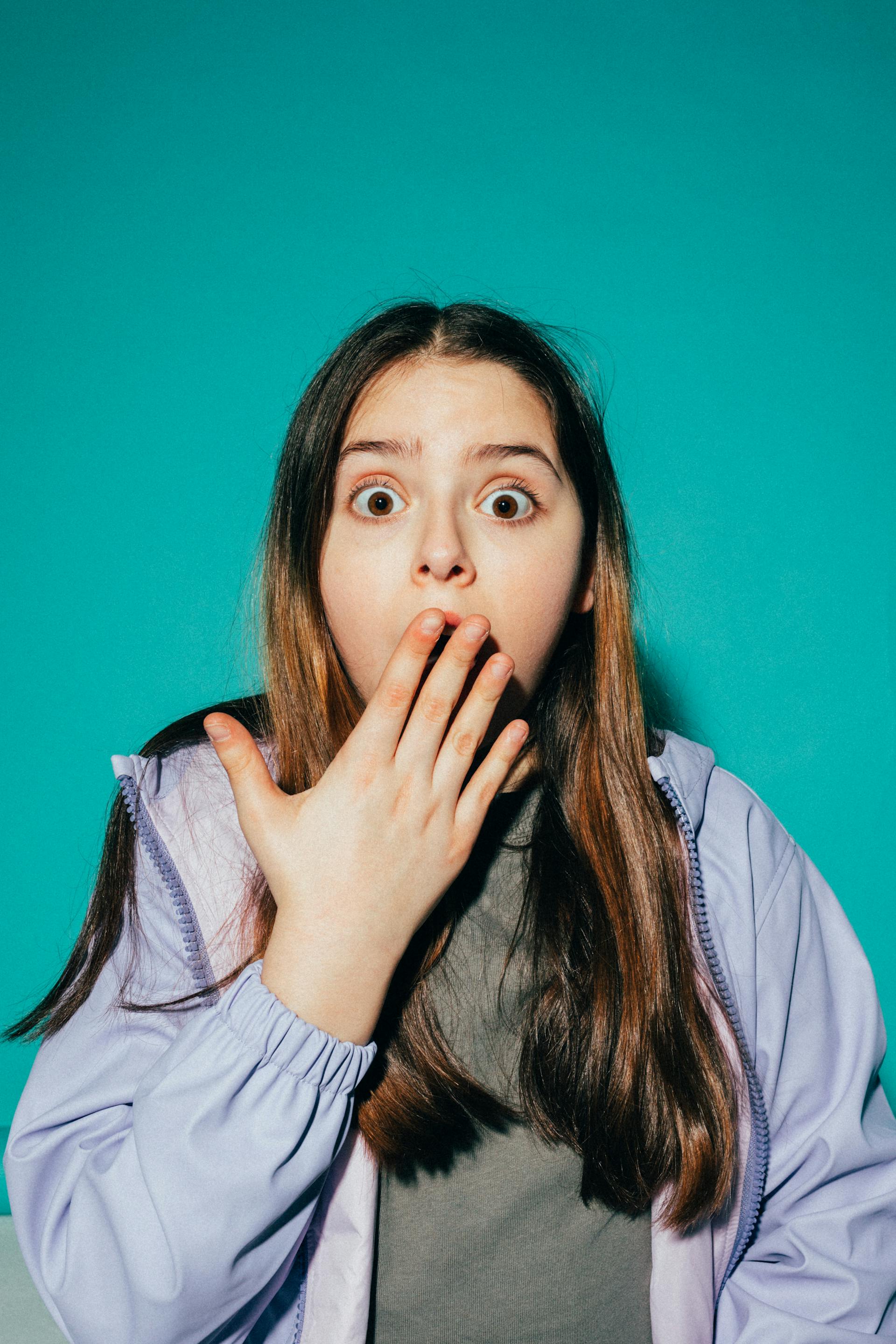 A startled teenage girl covering her mouth in shock | Source: Pexels