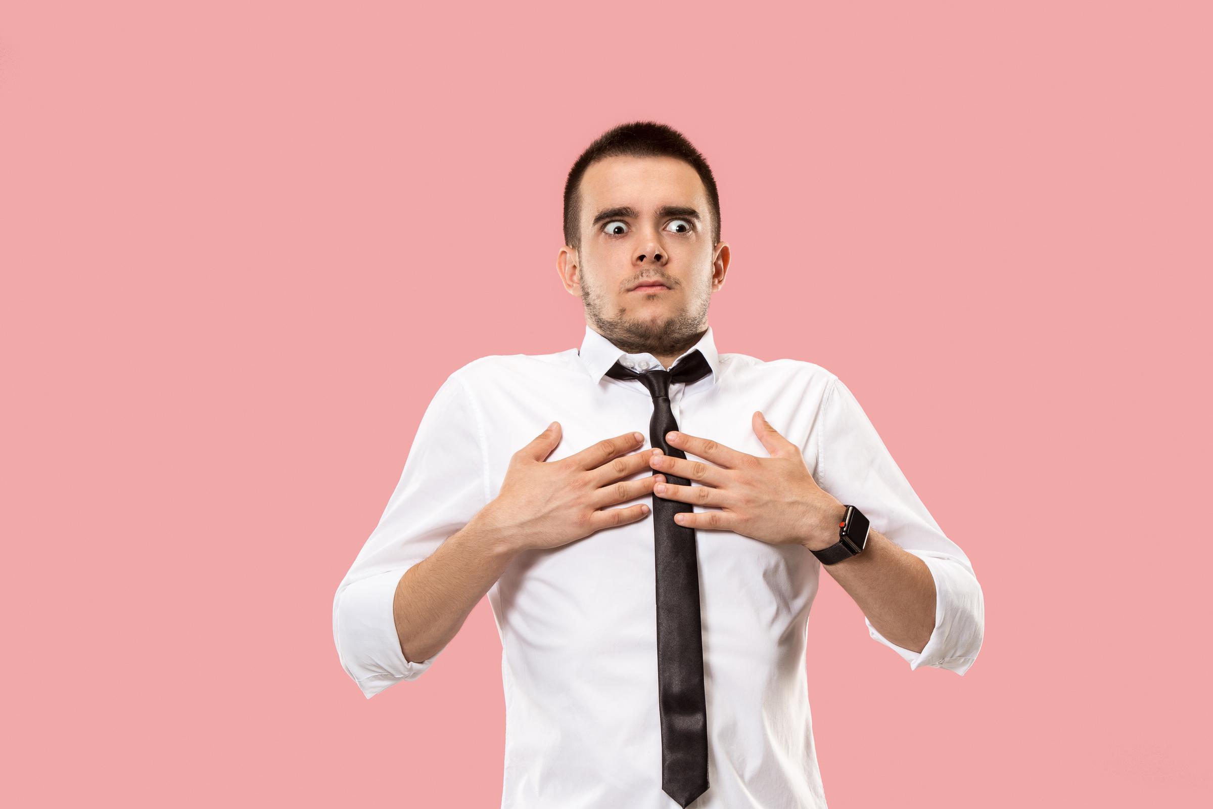 A shocked man on a pink backdrop | Source: Freepik