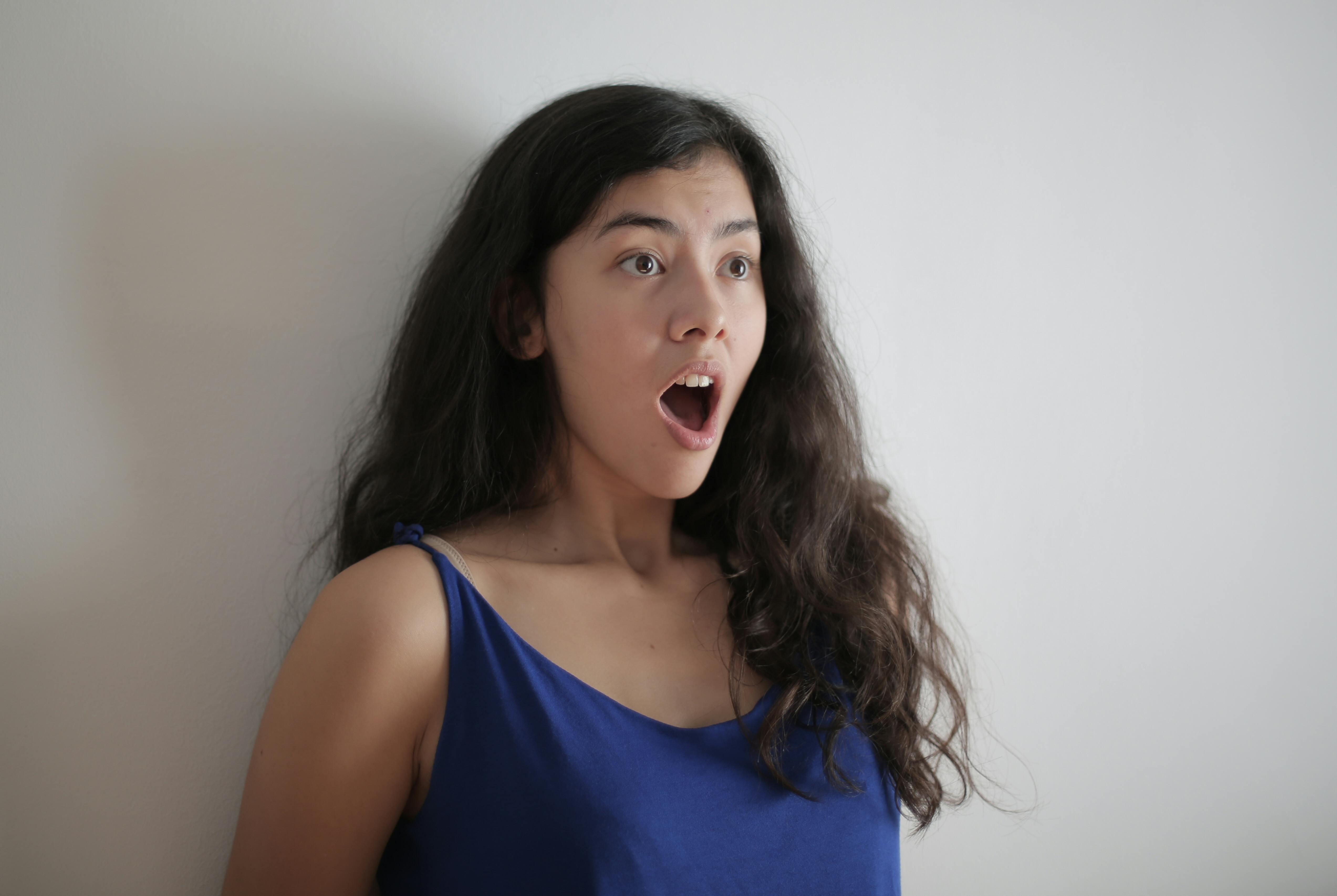 A shocked woman on a white backdrop | Source: Pexels