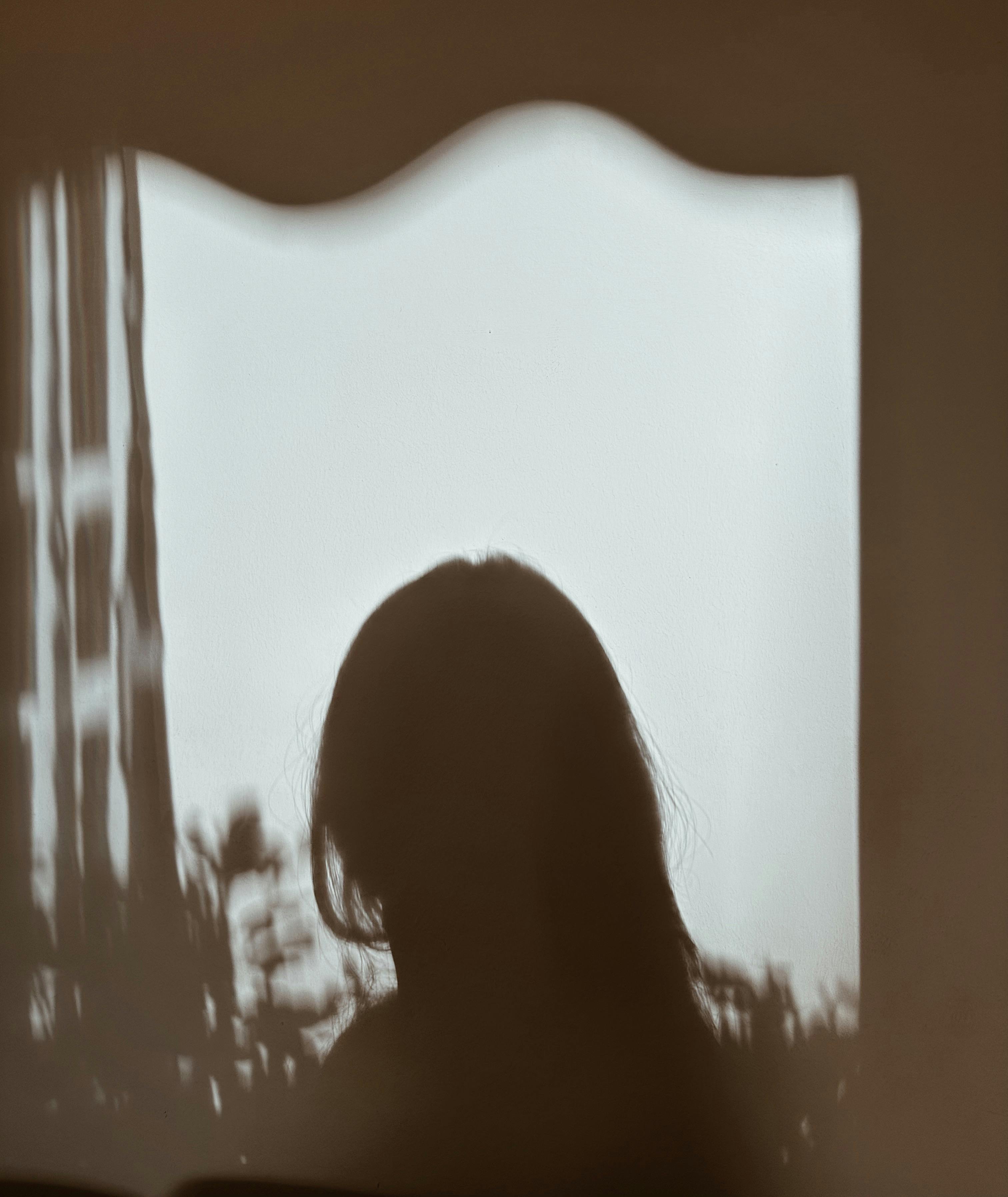 A reflection of a woman's silhouette by the window | Source: Pexels