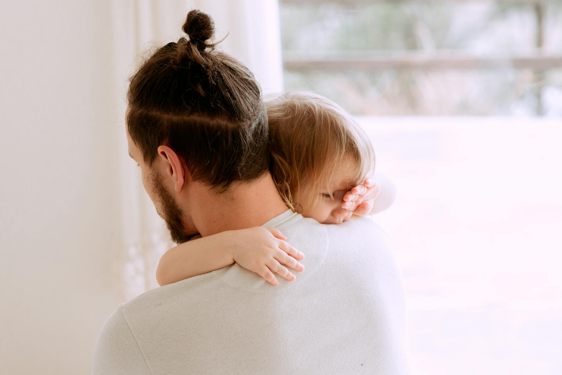 A man holding his little daughter | Source: Pexels