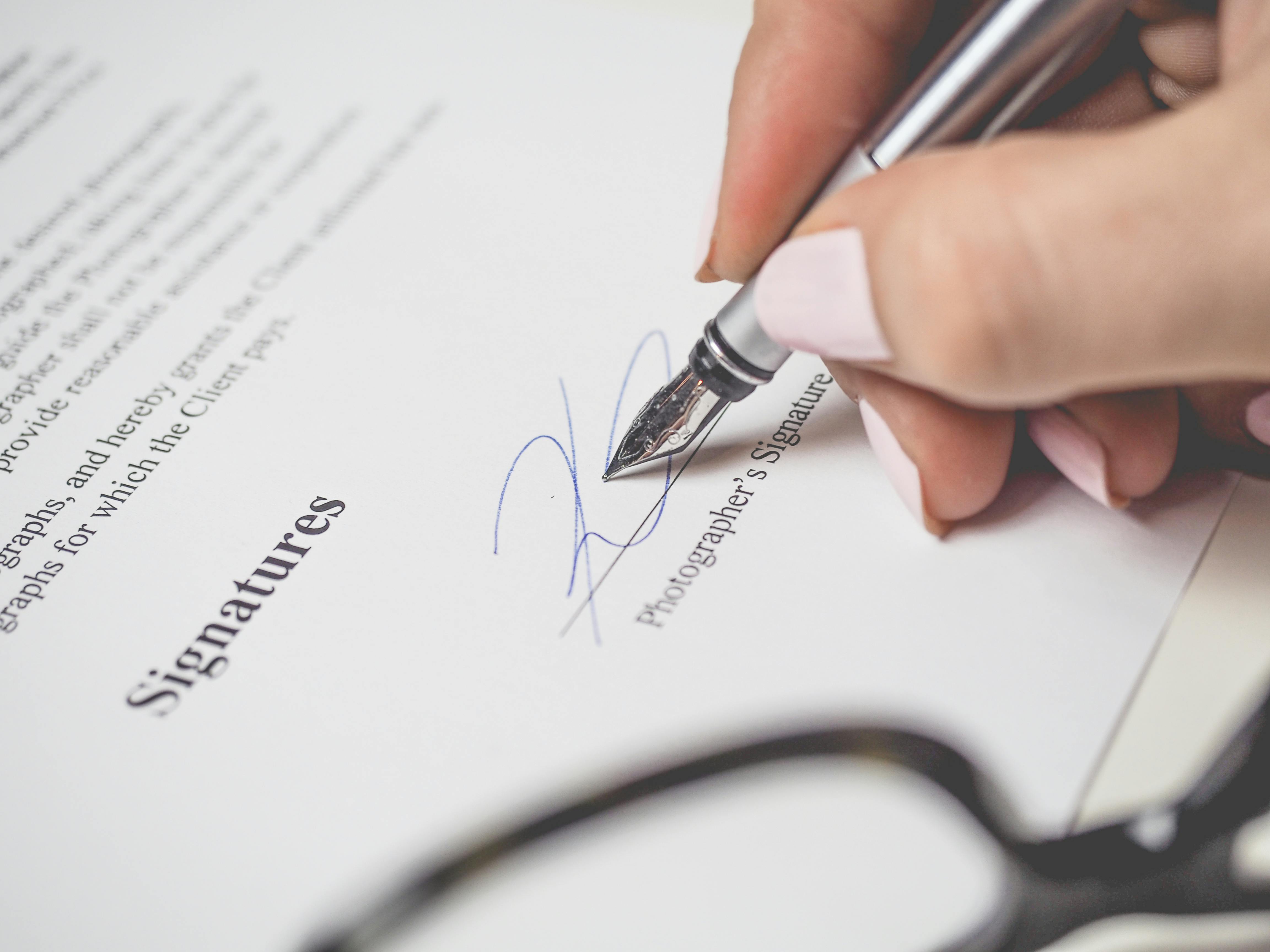 Woman's hand signing a paper | Source: Pexels