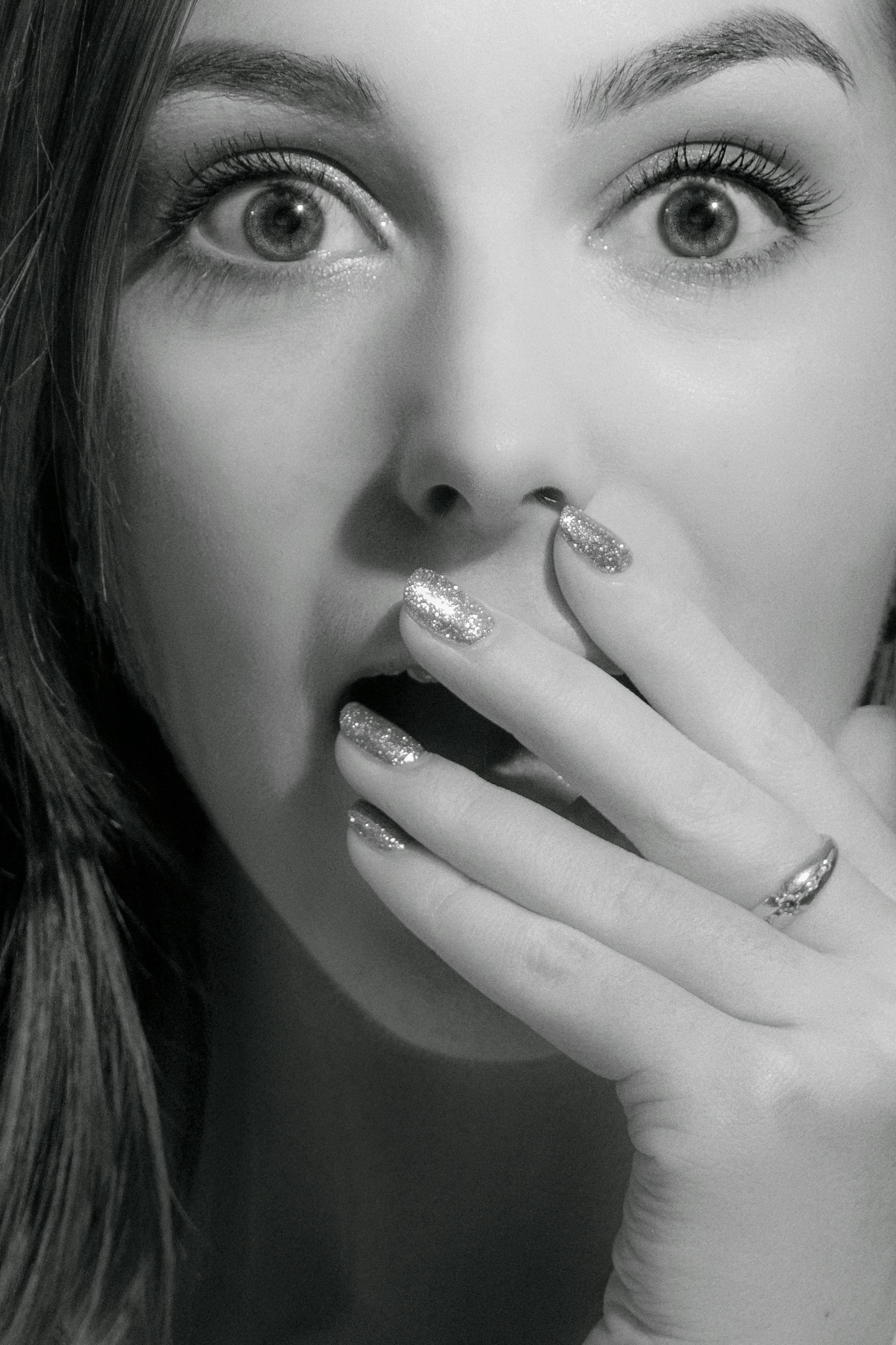 Grayscale of a startled woman covering her mouth | Source: Pexels