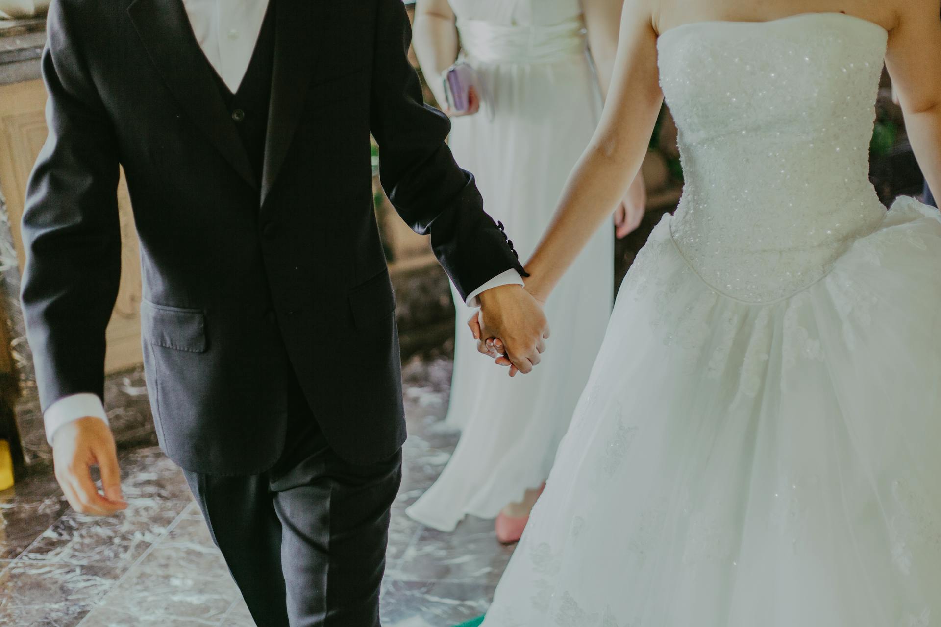 A couple holding hands on their wedding day | Source: Pexels