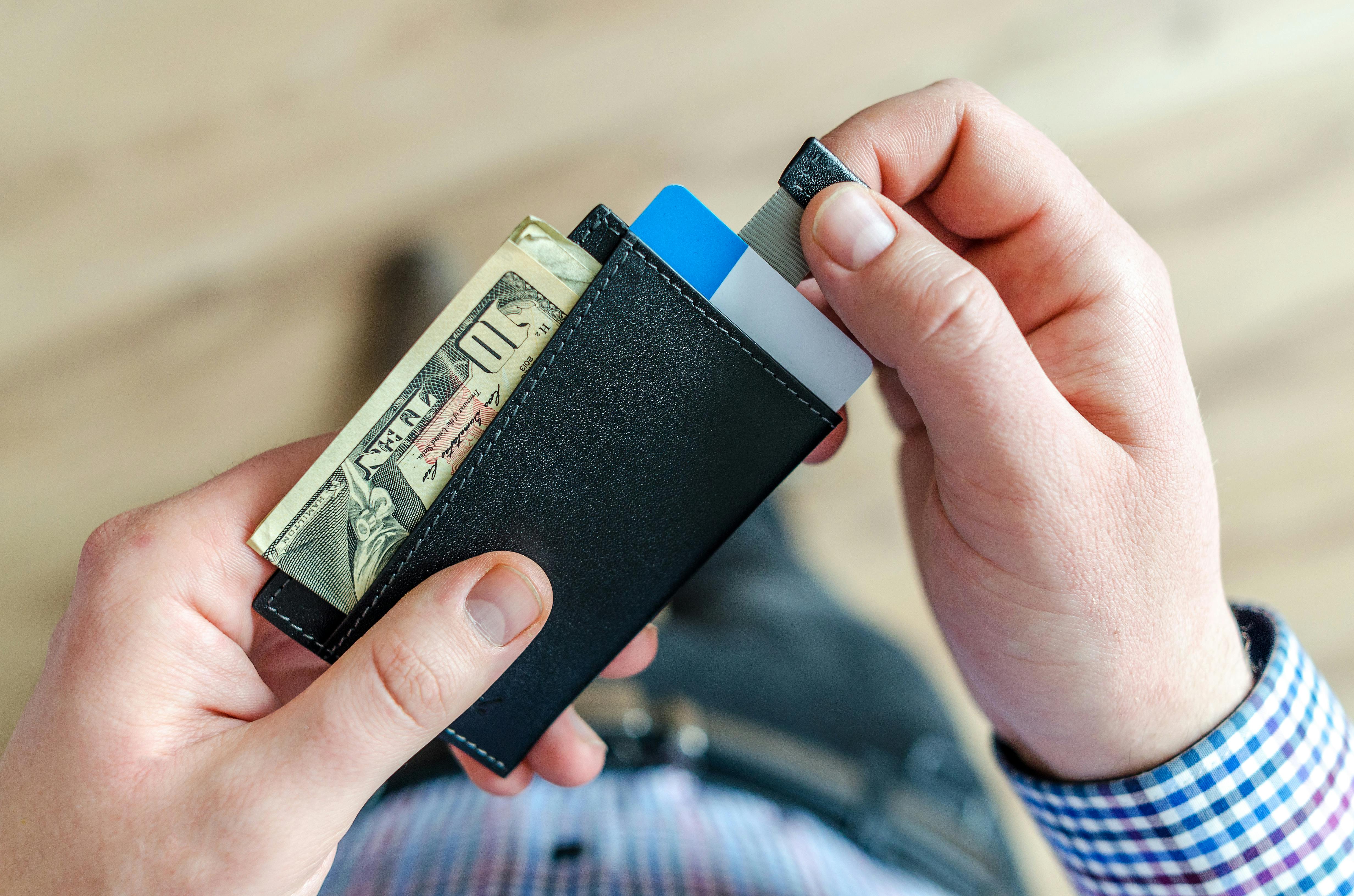 A man pulling out bills from his wallet | Source: Pexels