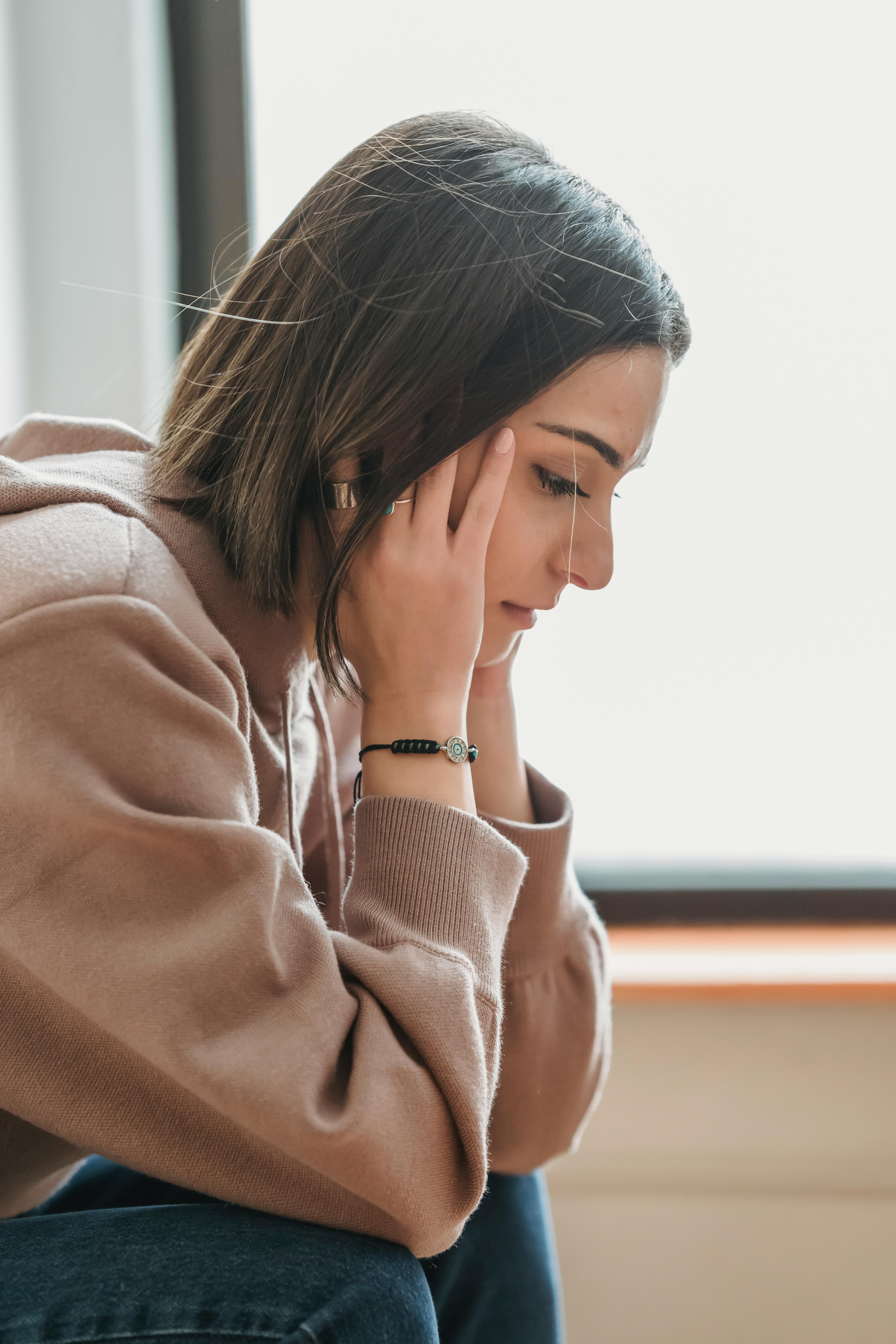 A sad woman with her hands on her head | Source: Pexels