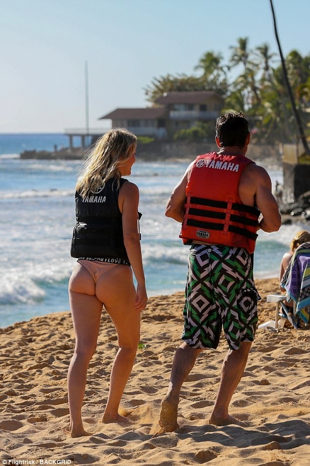 Cheeky: Dennis' lady, flaunted her flat stomach and her perky derriere in a revealing black, white and peach colored bikini