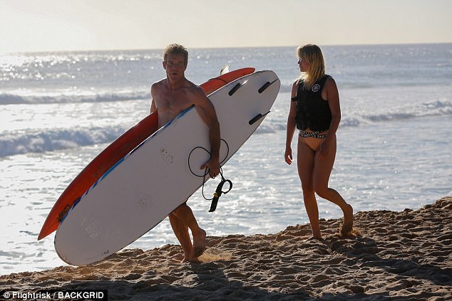 What  a gentleman: Dennis carried both of their surfboards as Santa looked on