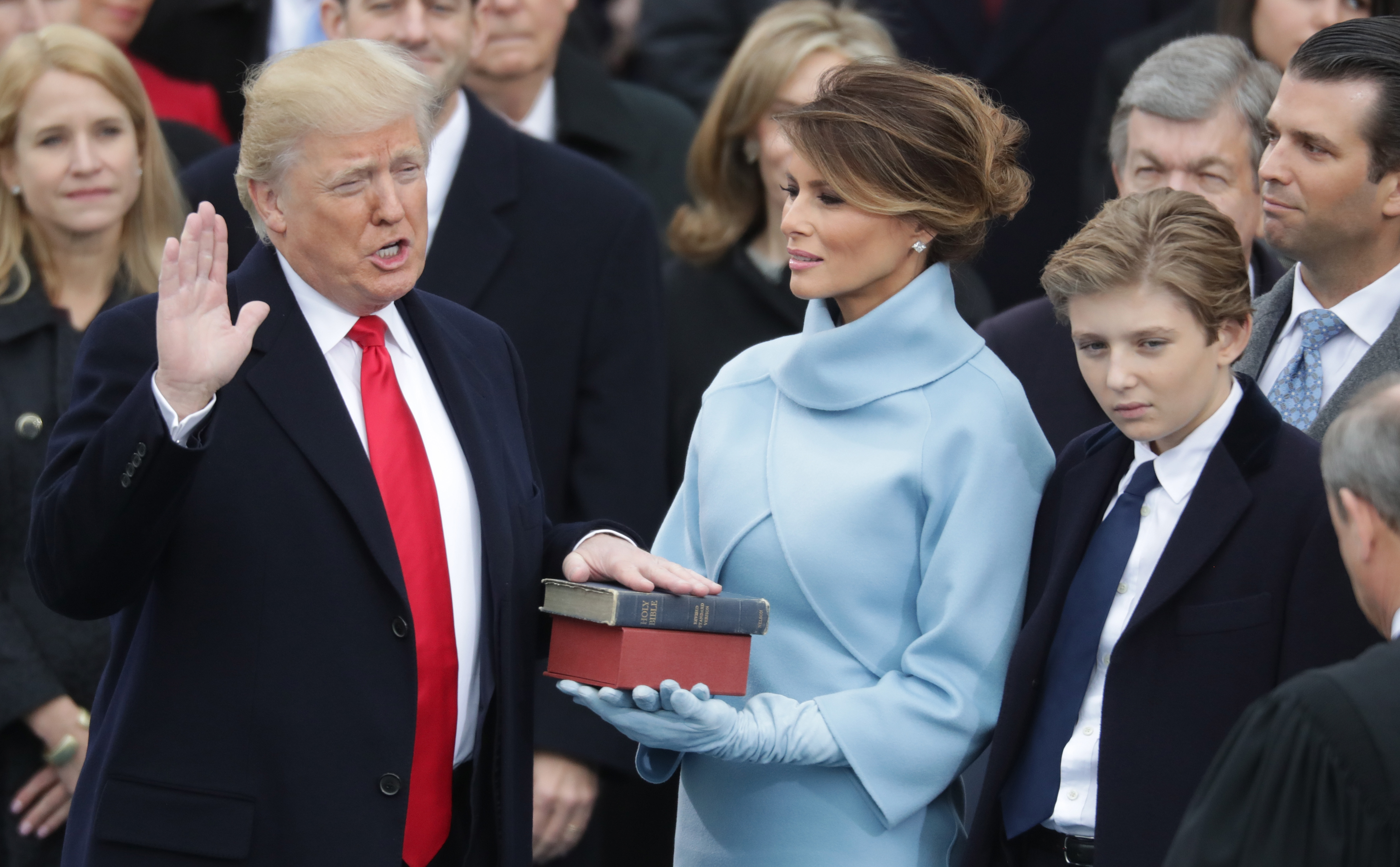 Donald Trump takes the oath of office as Melania Trump holds the bible and Barron Trump looks on, on the West Front of the US Capitol in Washington, DC, on January 20, 2017 | Source: Getty Images