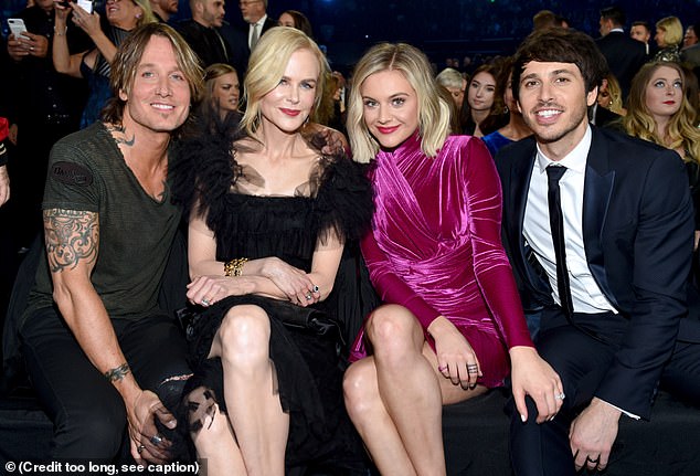Stars: Nicole's black top was covered in feathered accents and featured a low neckline